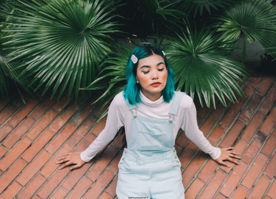 photo of woman sitting beside plants