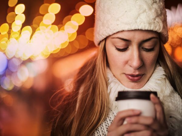 woman with takeaway hot drink on street in cold weather