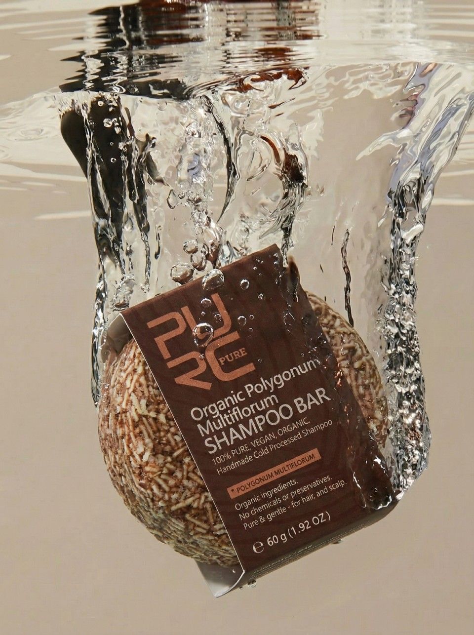 A collection of PURC Organics shampoo bars in various colors on a bamboo mat with lavender and rosemary sprigs.