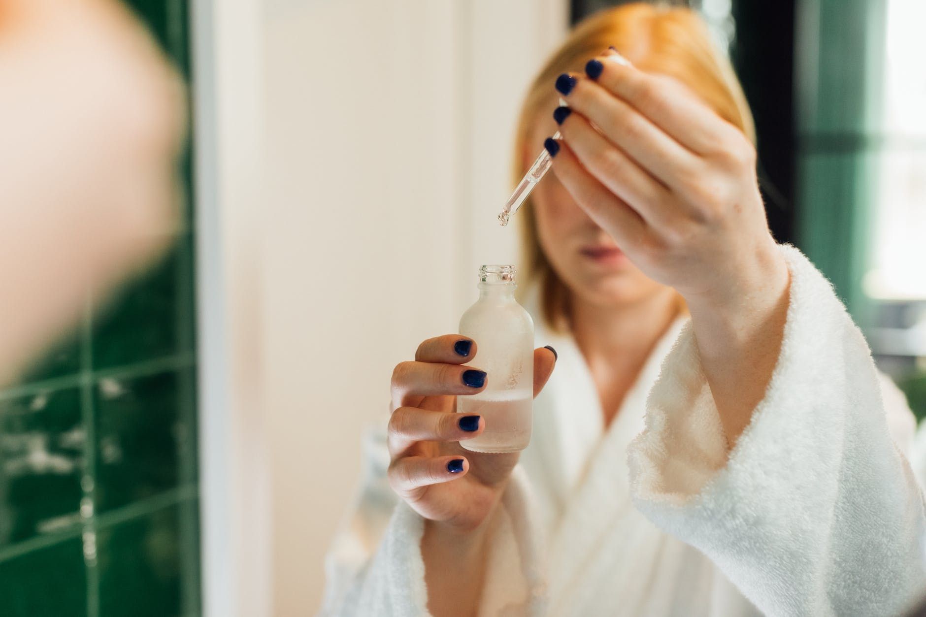 reflection of a woman holding a bottle of serum